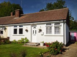 CheveleySpurling Cottage的白色房子,有棕色的屋顶