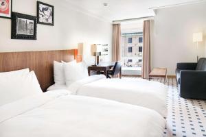 卑尔根卑尔根皇家丽笙酒店的酒店客房设有三张床和一张书桌