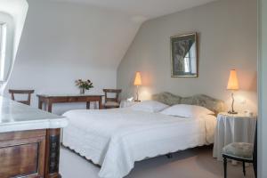 Saint-Fort-sur-Gironde塞勒斯城堡宫旅馆的卧室配有一张白色大床和两盏灯。