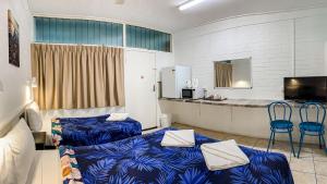 玛丽伯勒马里伯勒市汽车旅馆的一间设有两张蓝色的床和一个柜台的房间