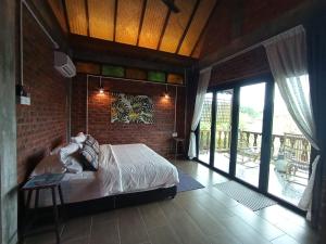 珍南海滩兰卡威达文木屋的一间卧室设有一张床和砖墙