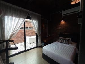 珍南海滩兰卡威达文木屋的一间卧室设有一张床和一个大窗户