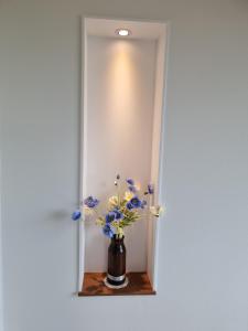 庆州Stay Gyeongju的花瓶,花瓶上摆着蓝色和白色的花朵