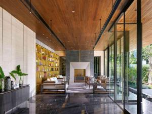 攀瓦海滩V Villas Phuket, MGallery的客厅设有木制天花板和玻璃墙