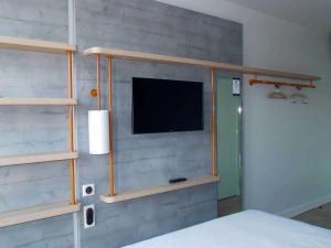 鲁昂ibis budget Rouen Centre Rive Gauche的一间卧室配有一张床,墙上配有电视