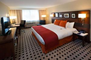 哈里斯堡Penn Harris Hotel Harrisburg, Trademark by Wyndham的酒店客房设有一张大床和一台电视。