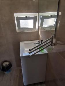 塞辛布拉Casa da Praia Alfarim的浴室设有白色水槽和镜子