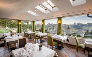 维兰德罗Granpanorama Wellnesshotel Sambergerhof Superior的餐厅设有桌椅和大窗户。