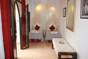 马拉喀什耶南埃尔卡迪摩洛哥传统庭院住宅的一间设有两张床和一张桌子的房间