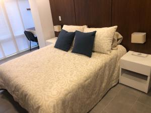 波哥大Apartamentos Edificio San Miguel Bogotá的一间卧室配有一张带蓝色枕头的床和一张桌子