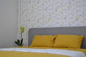 克列缅丘格Honey Bunny的卧室里一张带黄色枕头的床