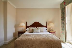 巴斯麦克唐纳德巴斯SPA度假酒店的一间卧室配有一张大床、两盏灯和一个窗户。