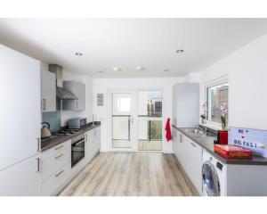贝尔法斯特Central Belfast Apartments Sandford的厨房铺有木地板,配有白色橱柜。