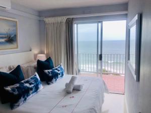乌姆德洛蒂Sands Beach Breaks Umdloti Beach View的一间卧室设有一张床,享有海景
