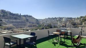 安曼Layaali Amman Hotel的设有带桌椅的市景阳台。