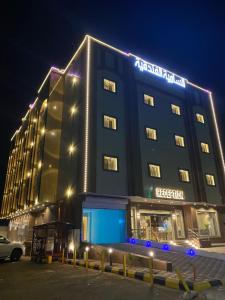 沙鲁拉السامية الفندقية的夜间标有标志的酒店大楼