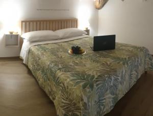 维罗纳B&B La casa di Ale的一间卧室配有一张带笔记本电脑的床
