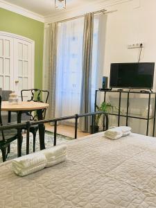 索普隆Fidelissima Apartman的一间卧室配有一张床、一张桌子和一台电视。