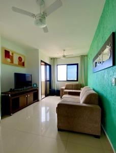 瓜鲁雅普莱雅恩赛亚达公寓的带沙发和平面电视的客厅