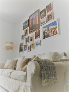 赫雷斯-德拉弗龙特拉El Envero Apartamento的客厅里的白色沙发,墙上挂着照片