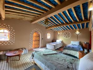 姆哈米德Camp Auberge Sahara Marokko的一间带两张床的卧室,位于木天花板的房间