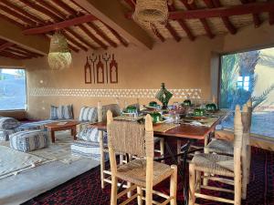 姆哈米德Camp Auberge Sahara Marokko的一间带木桌和椅子的用餐室