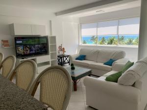 AricaguaCimarron Suites Playa Parguito的带沙发和电视的客厅