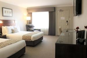 沃加沃加卡里乐套房公寓酒店的酒店客房设有两张床和电视。