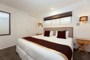 基督城菲诺酒店及套房 的一间卧室设有一张大床和一个窗户。