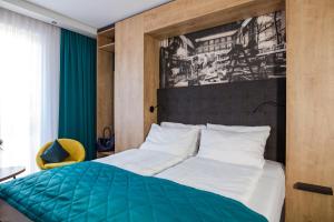 古梅尔斯巴赫Das Steinmüller Hotel的一间卧室配有一张带绿色和白色棉被的床