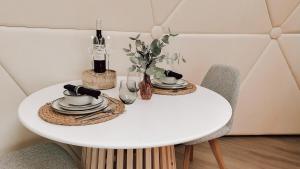 科克赛德Romantische glamping dome Koksijde - Duiniek的一张桌子、两把椅子和一张白色桌子,上面有盘子