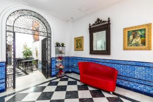 塞维利亚塞维利亚酷炫酒店的蓝色和白色瓷砖的房间的红色椅子