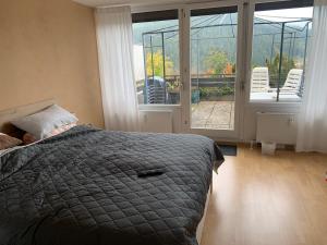 拜尔斯布龙Appartement mit herrlicher Aussicht übers Murgtal的一间卧室配有一张床,阳台配有椅子