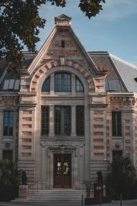 波尔多Hotel La Zoologie & Spa Bordeaux的一座大型砖砌建筑,门上方有拱门
