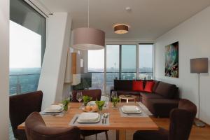 维也纳Triiiple Suites Level 22 mit Balkon und Tiefgarage的客厅配有桌子和沙发