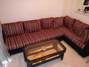 El Aouinarésidence les jardins的客厅里一张红色的沙发,配有茶几