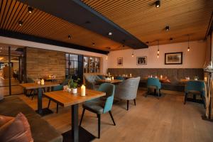 巴特克茨廷Hotel Amberger Hof的餐厅设有木制天花板和桌椅