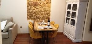 奥维多Ayuntamiento - Precioso con parking y WIFI的用餐室配有带一瓶葡萄酒的桌子