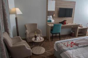 塔伊夫Fiori Hotels的酒店客房,配有一张床、一张桌子和椅子