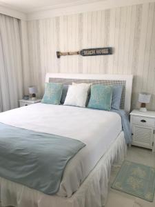 普拉亚多Apt Coral Azul Iberostate Praia do Forte的卧室配有带蓝色枕头的大型白色床