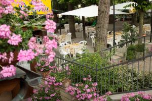 蒙特普齐亚诺Hotel Ristorante Tre Stelle的花园内种有粉红色的鲜花,配有桌椅