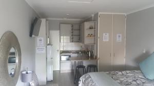 哈里史密斯THE SPARE BEDROOM Unit 2的一间卧室配有一张床,厨房配有白色橱柜