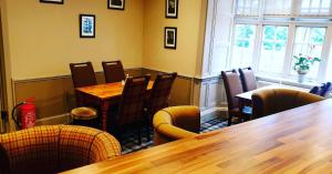 斯佩河畔格兰敦庭院酒店的餐厅设有木桌、椅子和窗户