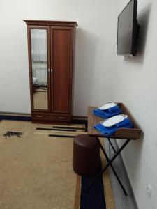 塔什干Chinara Guest House Airport的客房设有电视和带毛巾的桌子。