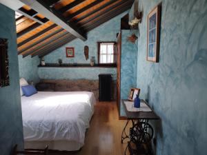 Barcia拉丰特乡村民宿的一间设有床铺的卧室,位于一间拥有蓝色墙壁的房间