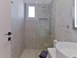 尼基季KaSta Family Apartments的带淋浴、卫生间和盥洗盆的浴室