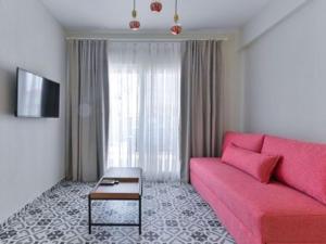 尼基季KaSta Family Apartments的客厅配有粉红色的沙发和桌子