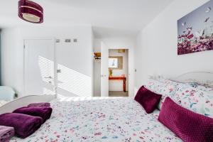 林德赫斯特Spire View - New Forest Holiday Home的白色卧室配有带紫色枕头的床