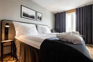 韦斯特罗斯克拉利奥伊特吉连锁酒店的卧室配有一张带白色床单和枕头的大床。