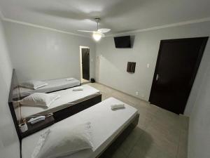 毛阿Hotel Ouro de Mauá的一间设有两张床和电视的房间